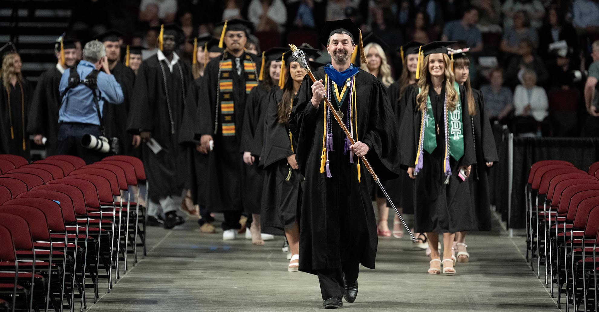 Faculty and students walk down the aisle during commencement exercises