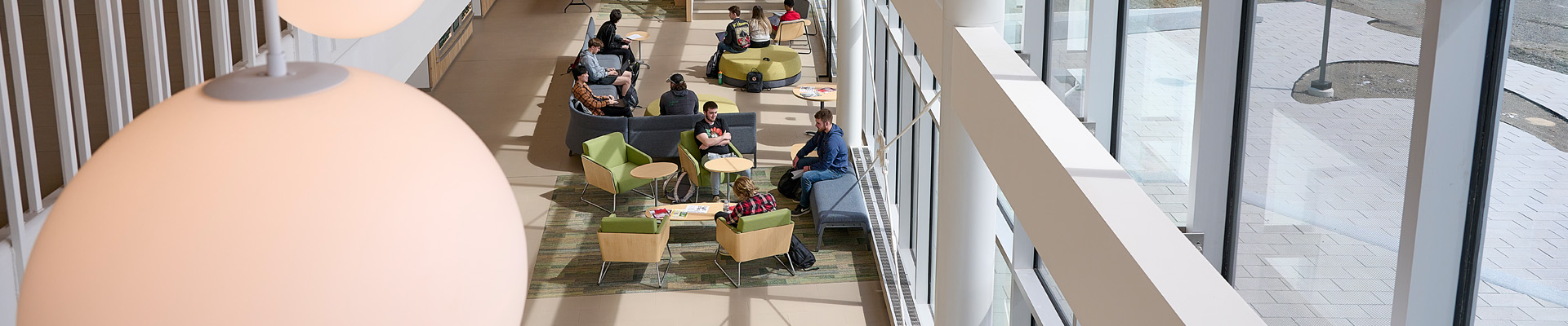Interior photo of Harold Alfond Hall with students studying in common area