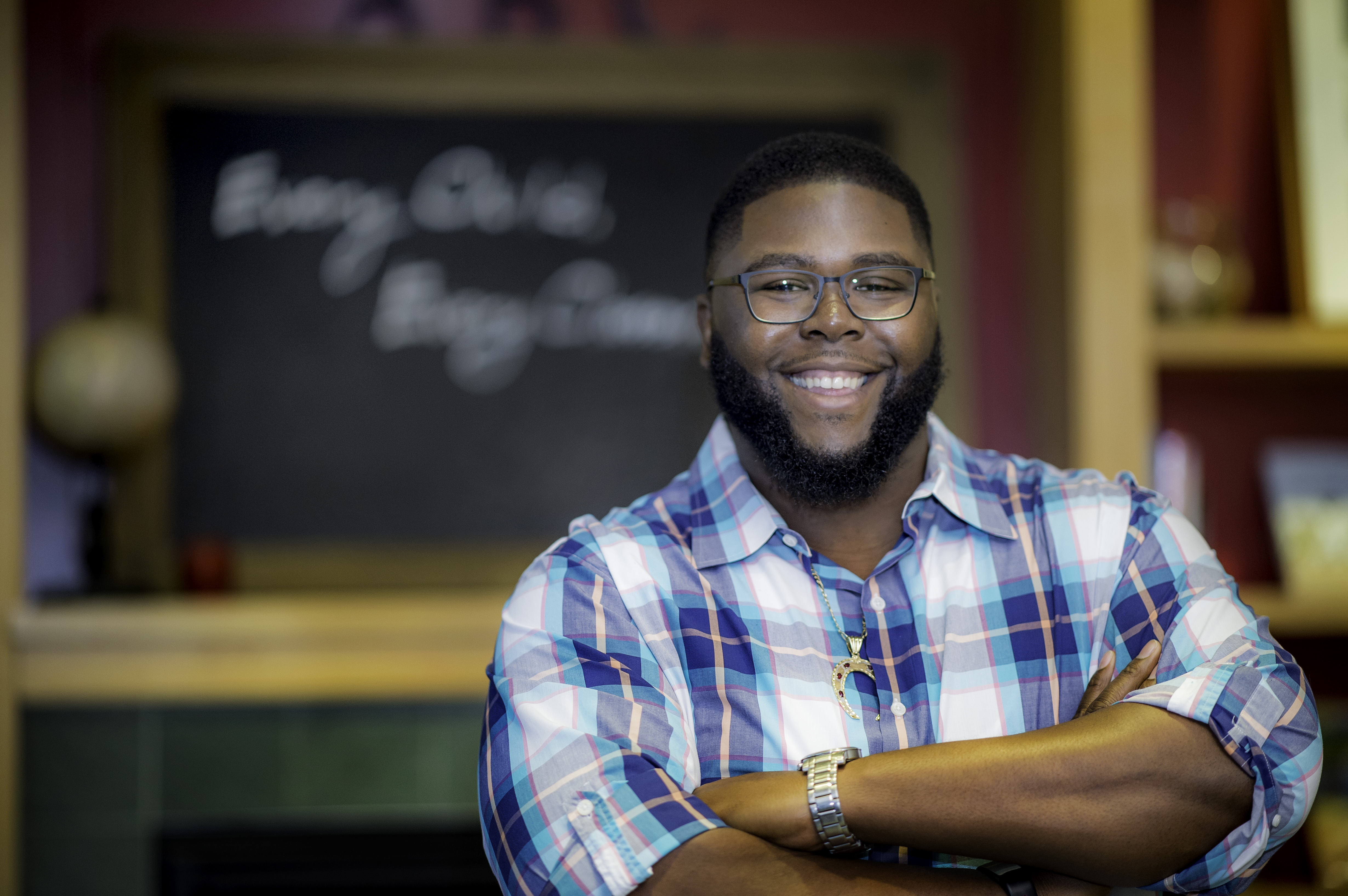 Anthony Jack poses while smiling and crossing his arms.