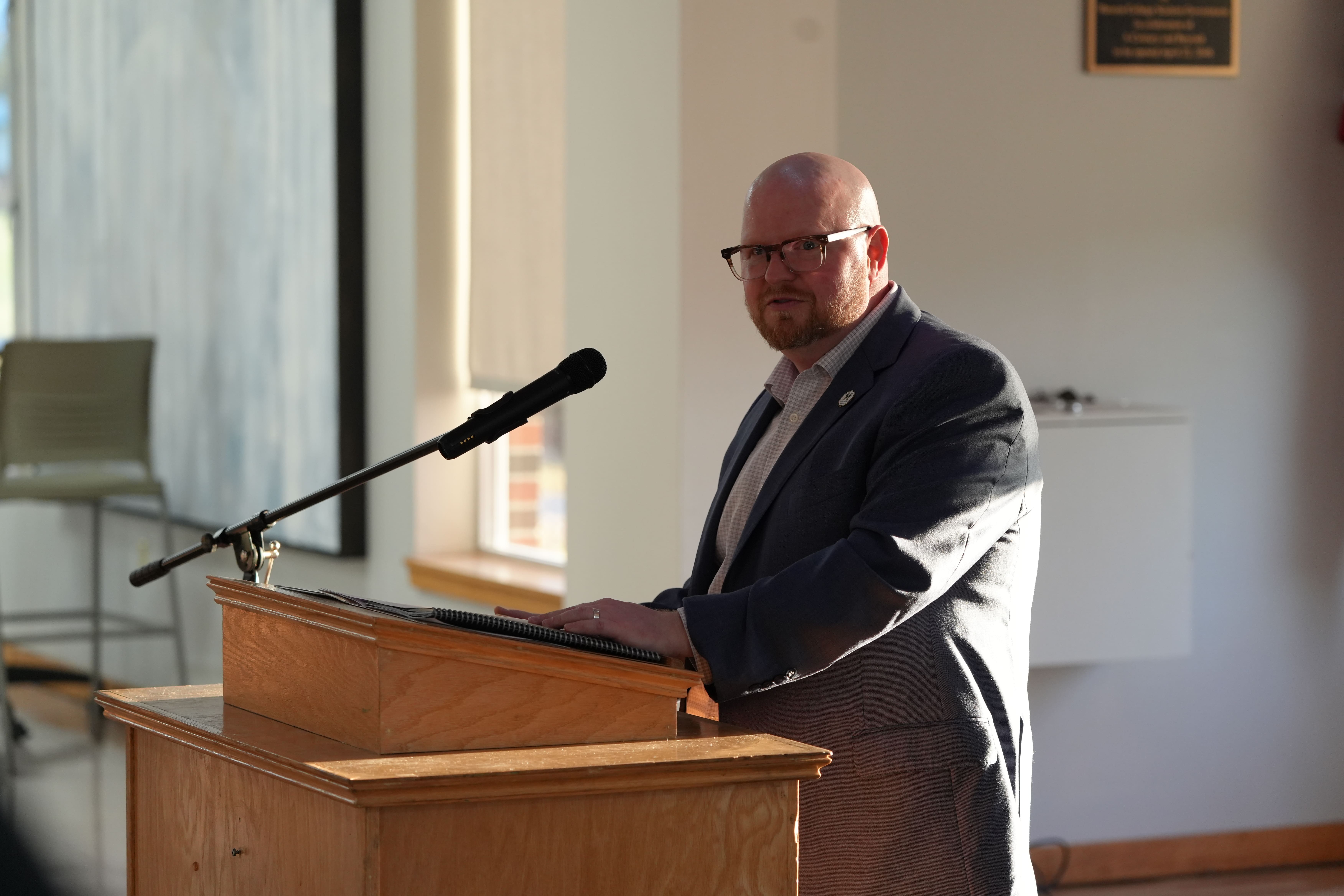 Troy Morehouse stands at a podium while speaking during Husson's First Generation Student Reception.