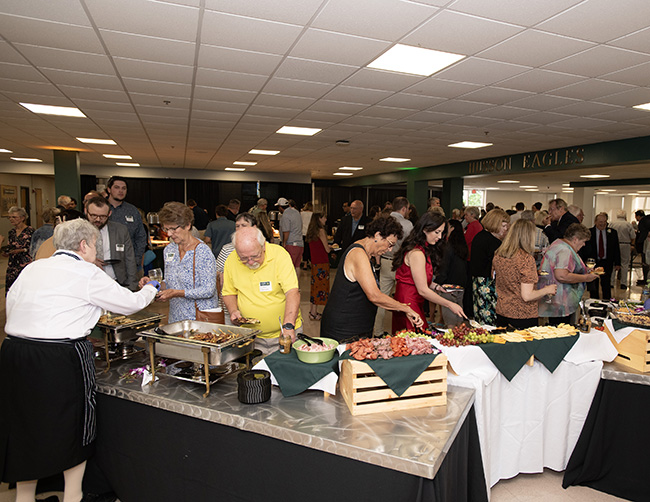 People are shown getting food at a fancy buffet table.