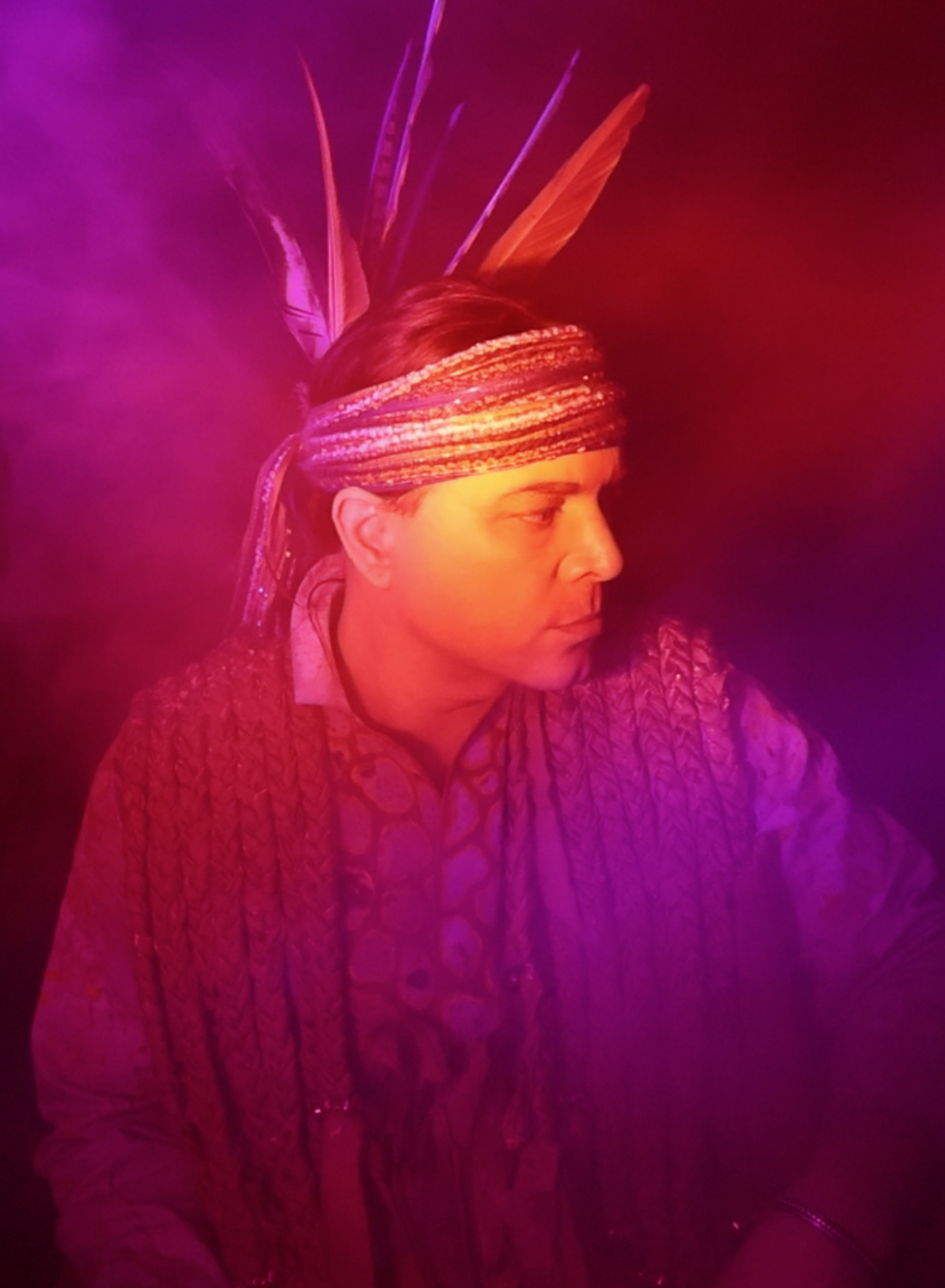 A stylized portrait of a man wearing indigenous clothing is shown. 