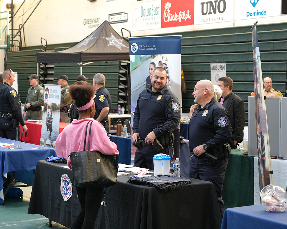 A student in a pink shirt speaks to two police officers.