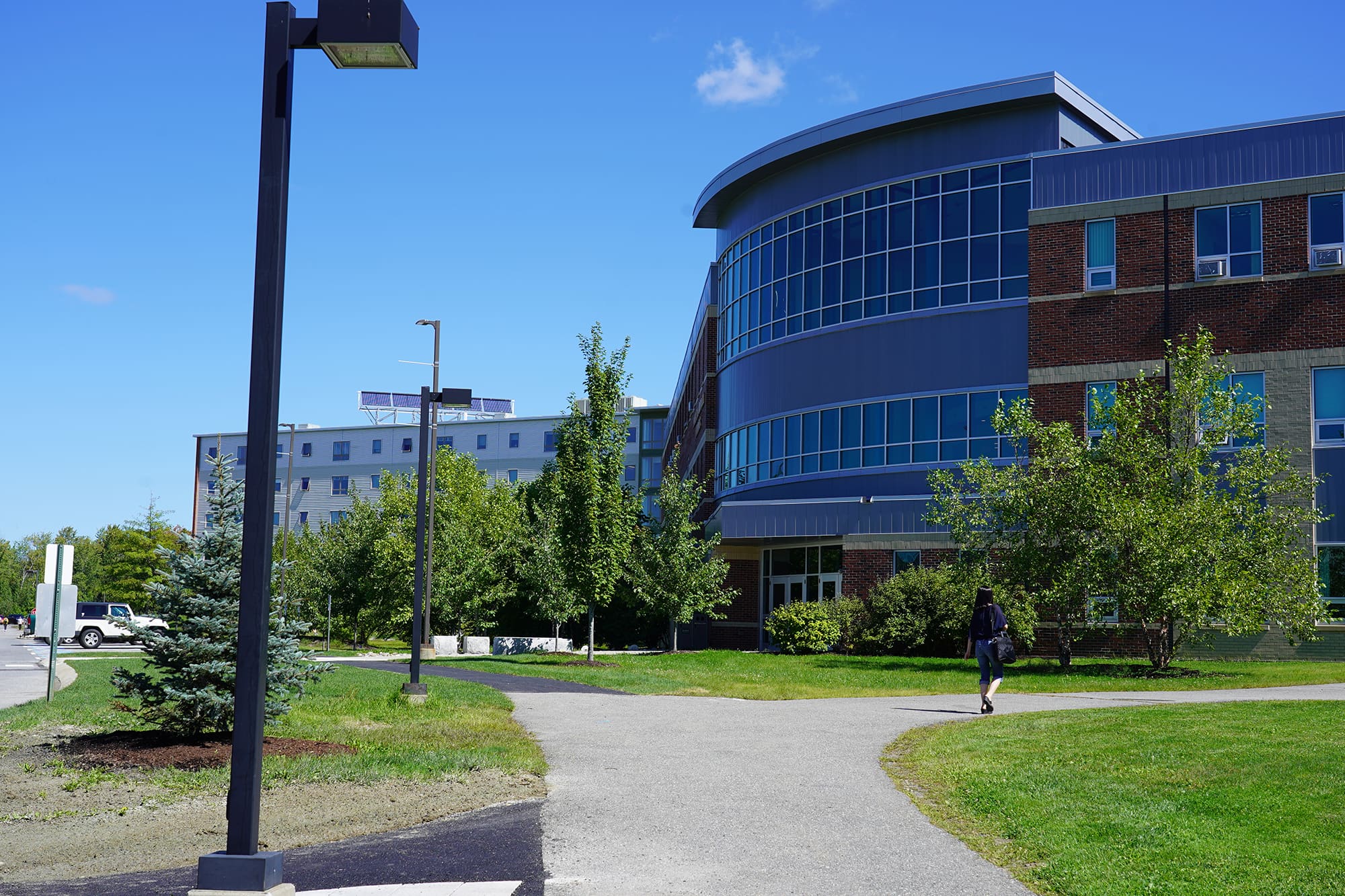 Multiple people walking outside through Husson University's campus.