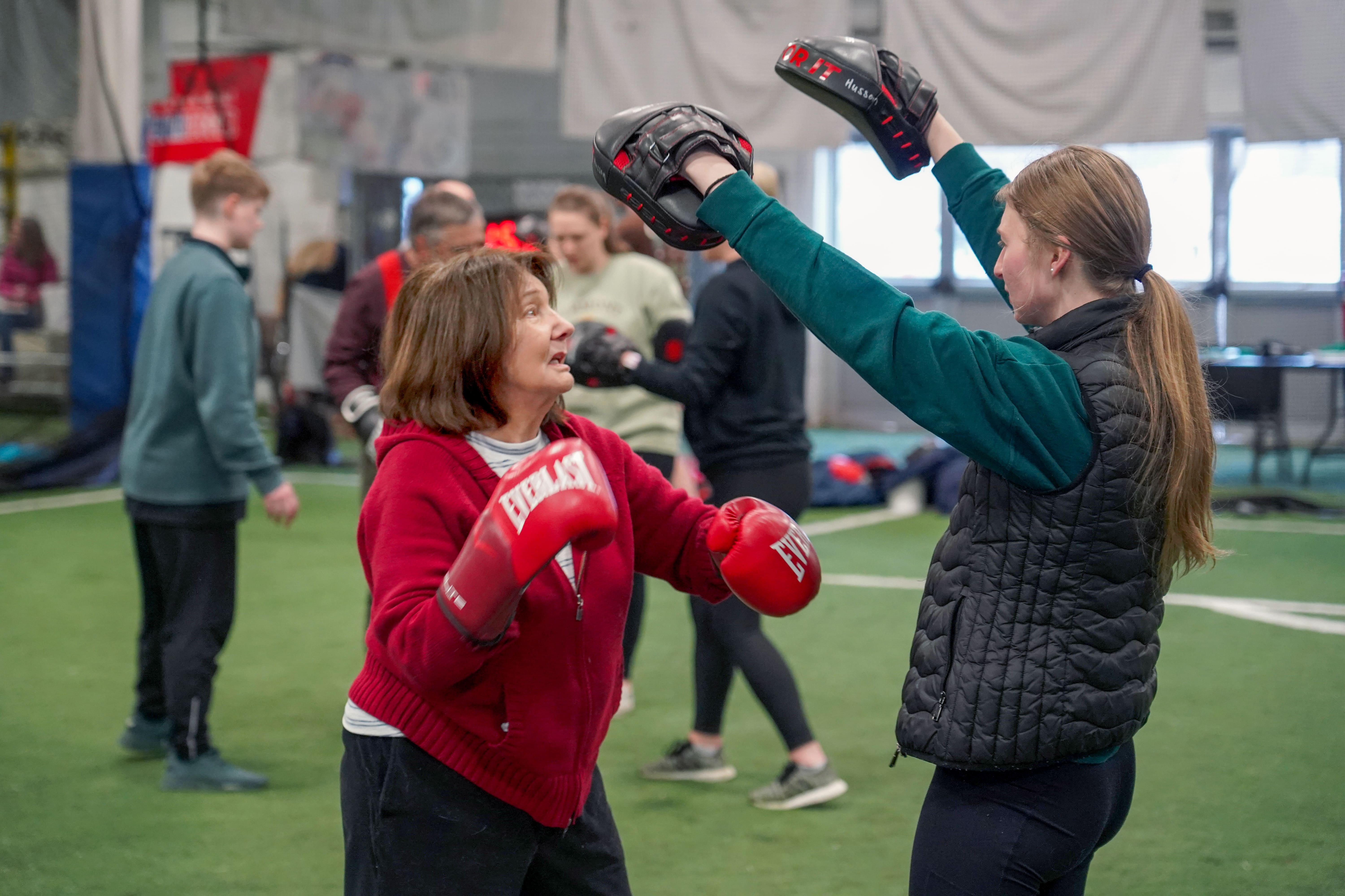 Husson student does boxing drill with individual.