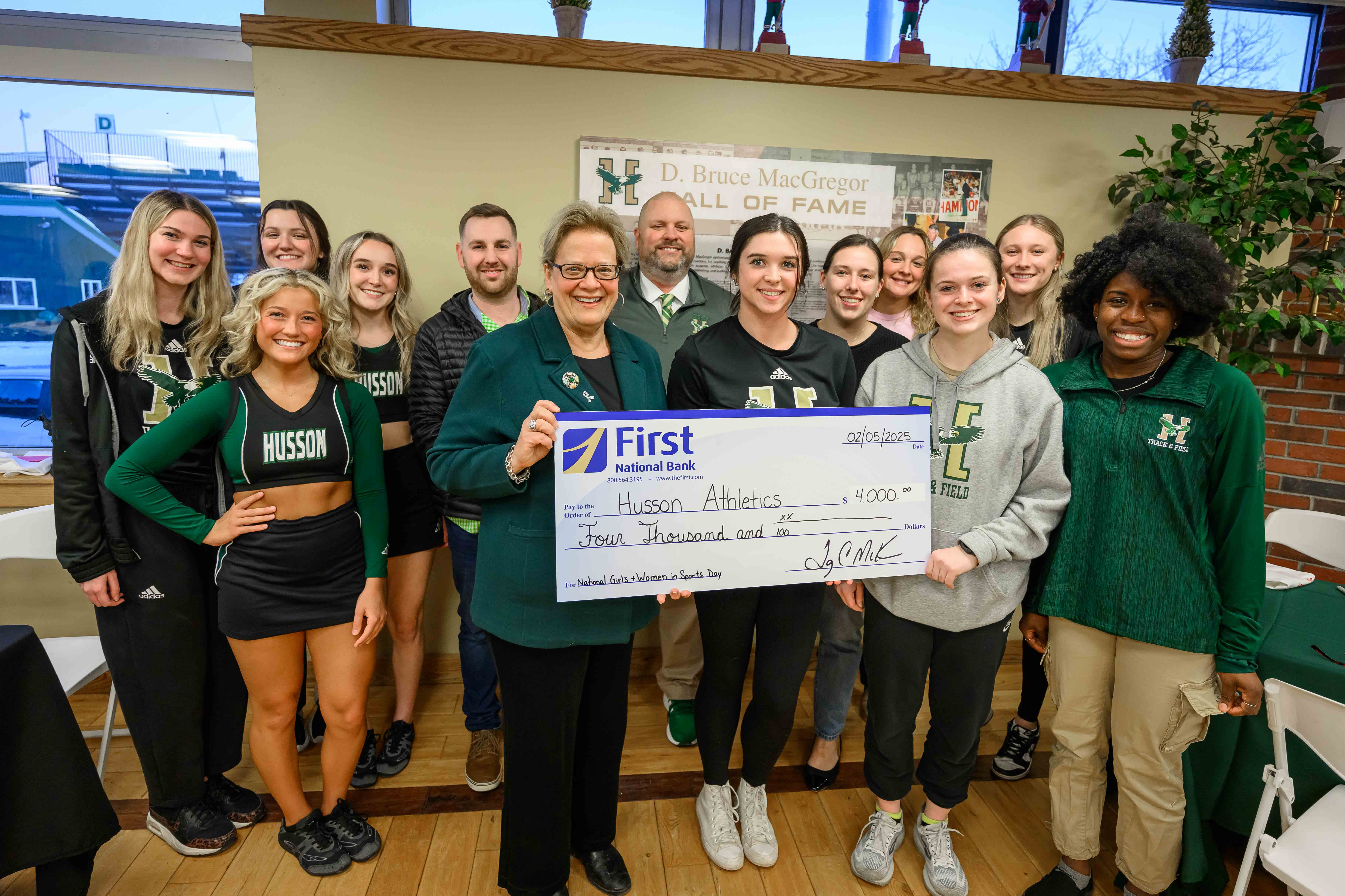 A group of women stand together holding a very large check.