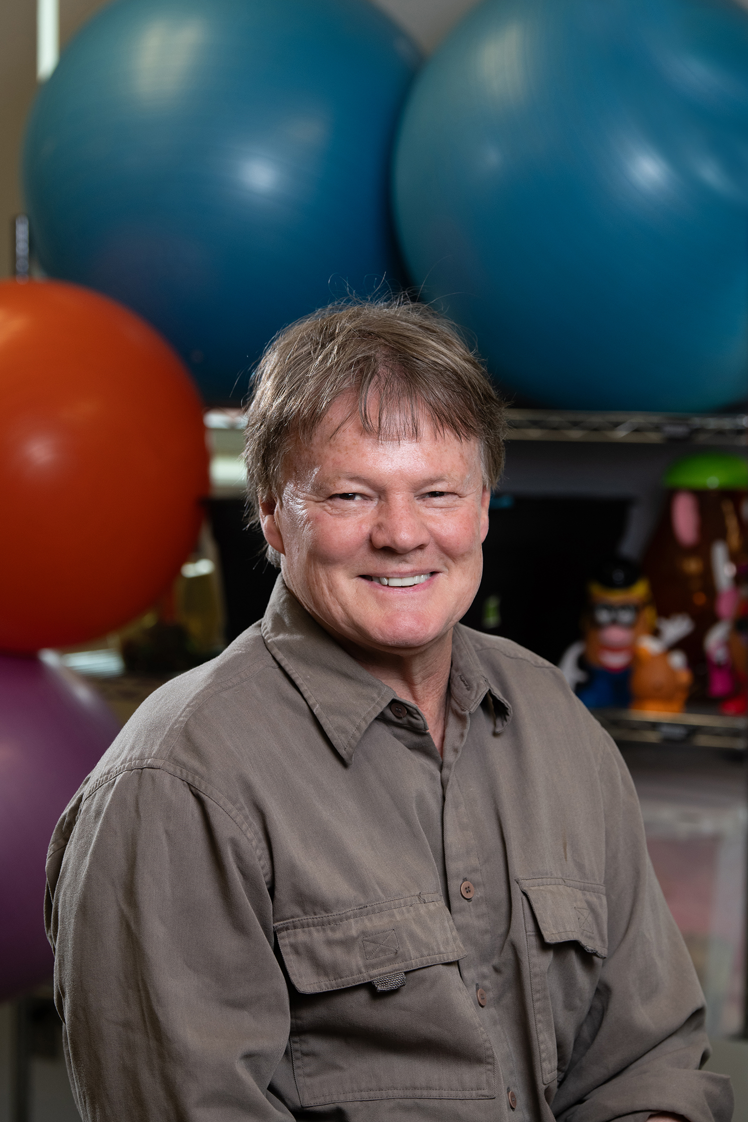 A portrait of a man in front of physical therapy implements is shown.