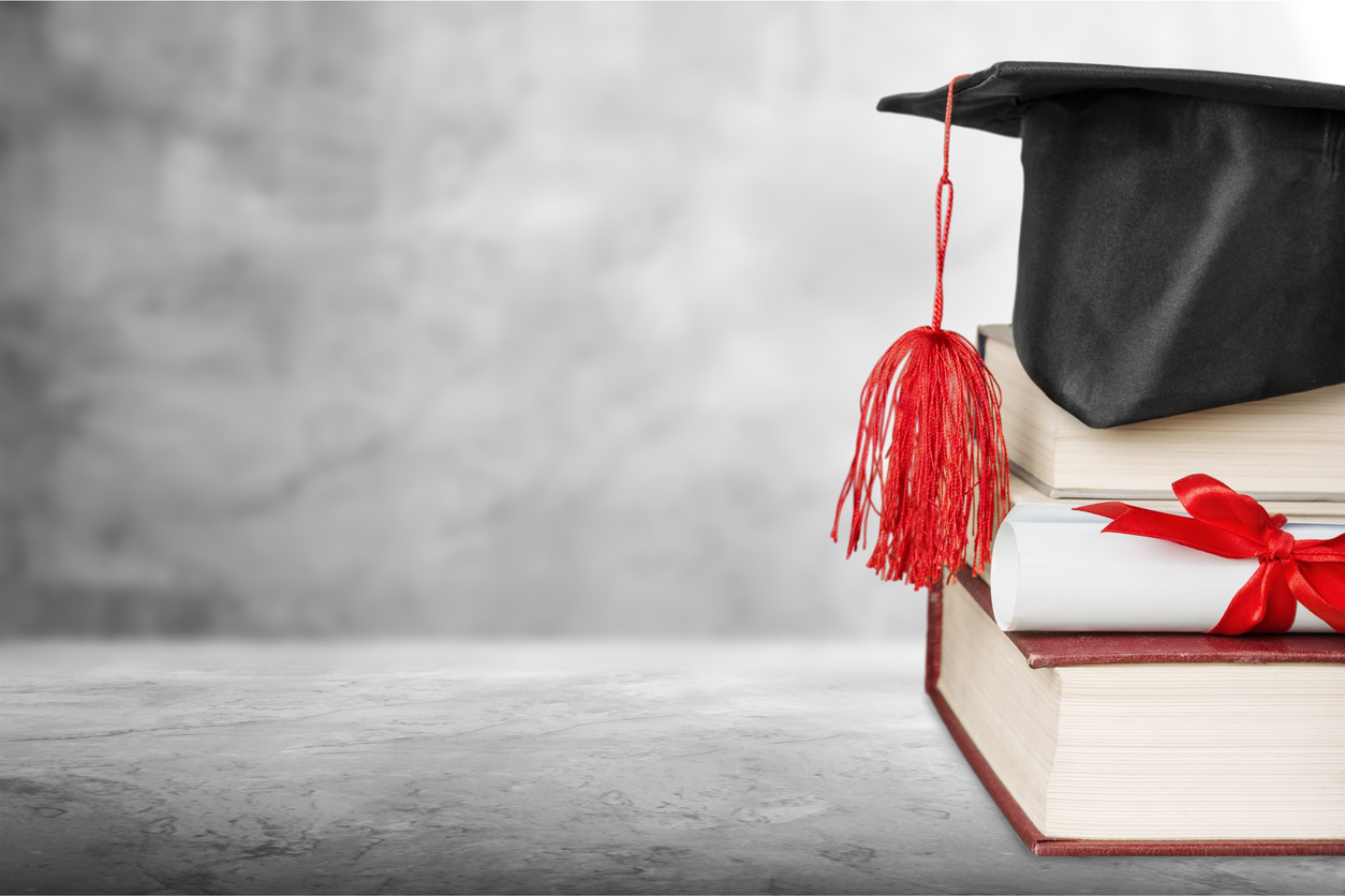 Graduation cap sitting on a stack of books.