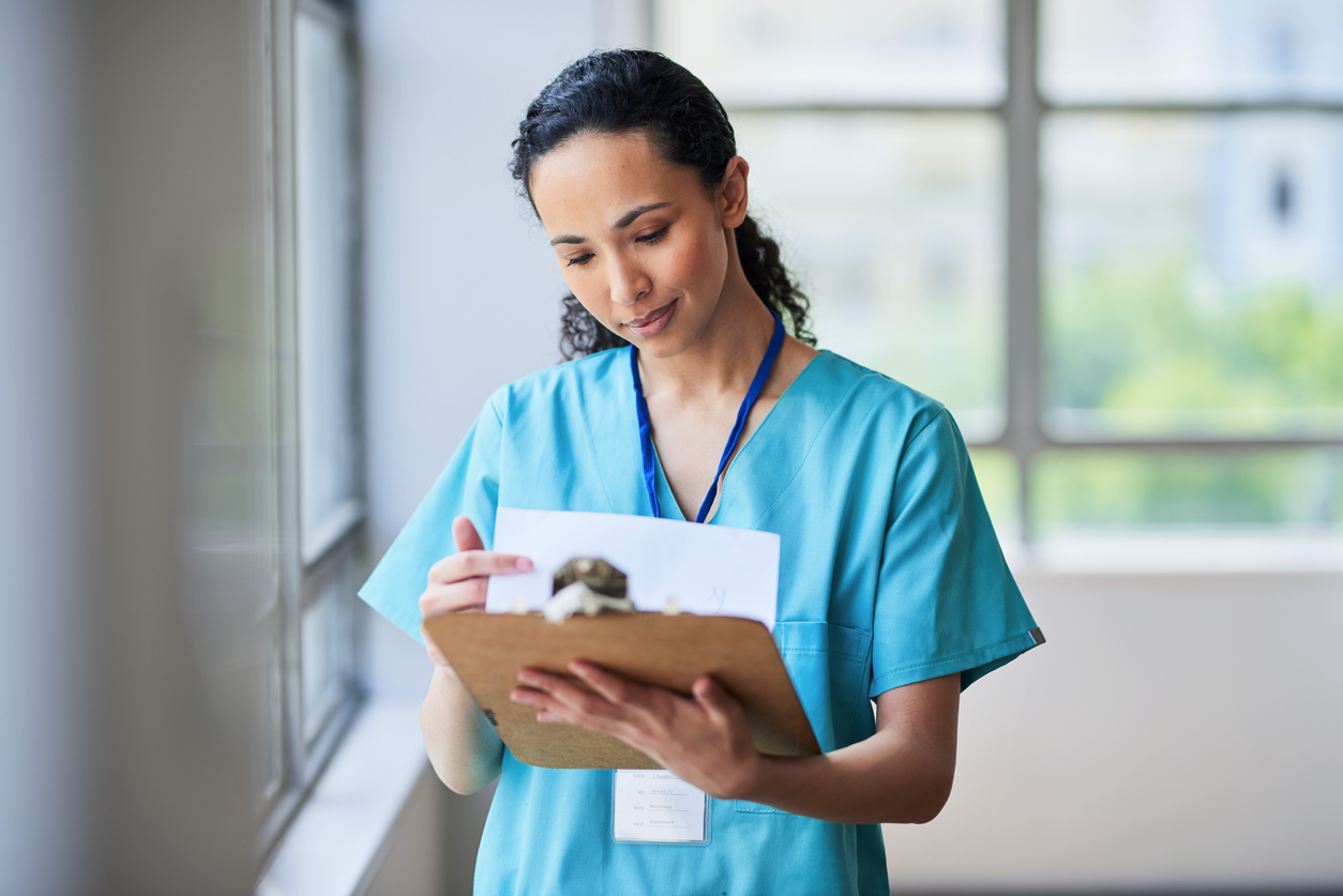 Nurse looking at note pad.