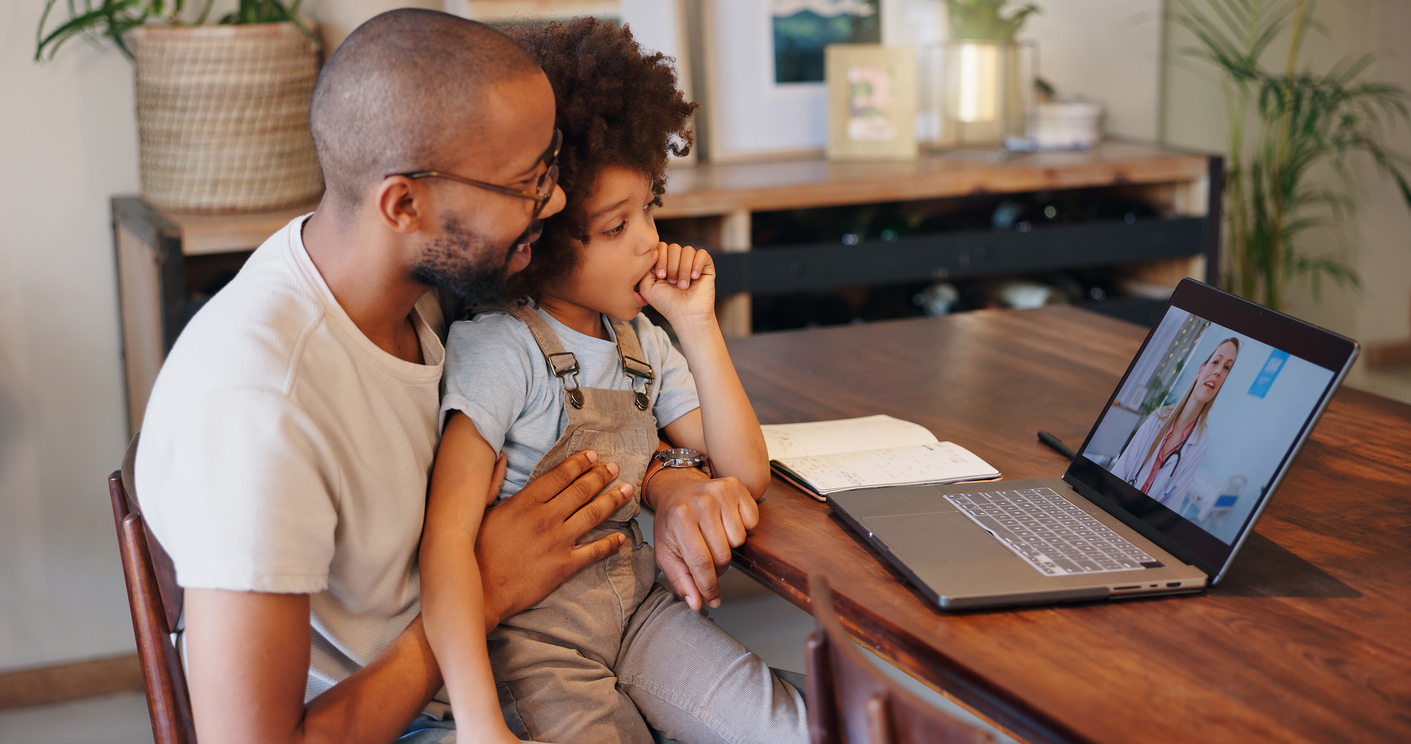 Father and daughter speaking with a nurse on a laptop during a telehealth appointment.